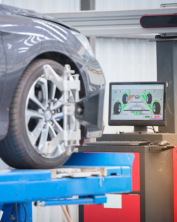 Computer monitor showing car axle information with SUV in background