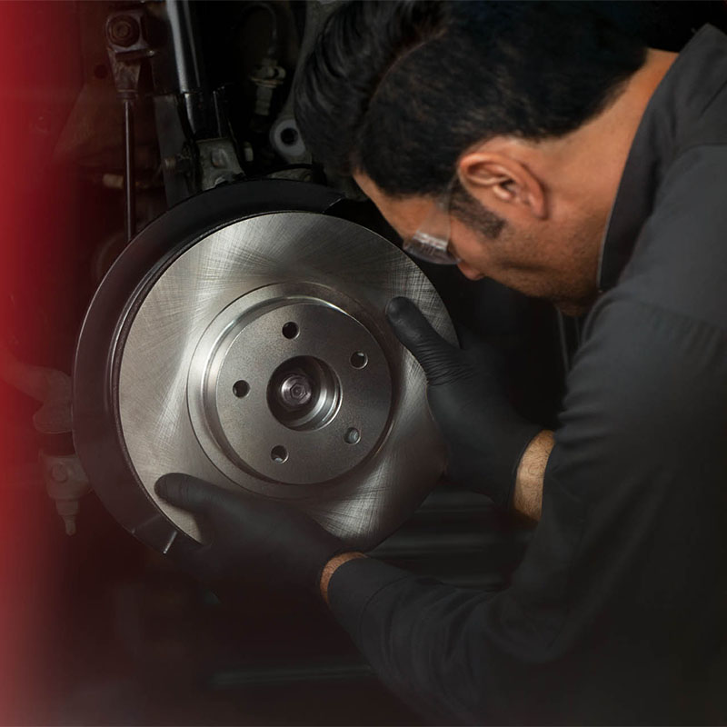 Mechanic inspecting car brakes